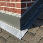 Close-up view of properly installed metal roof flashing around chimney preventing water damage