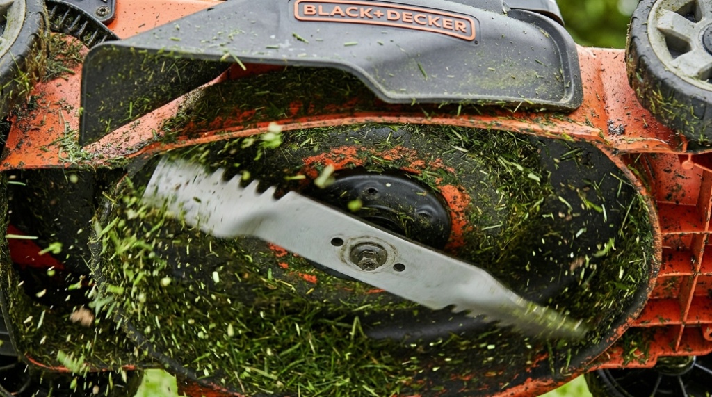Close-up of lawn mower mulching blade cutting grass into fine pieces.
